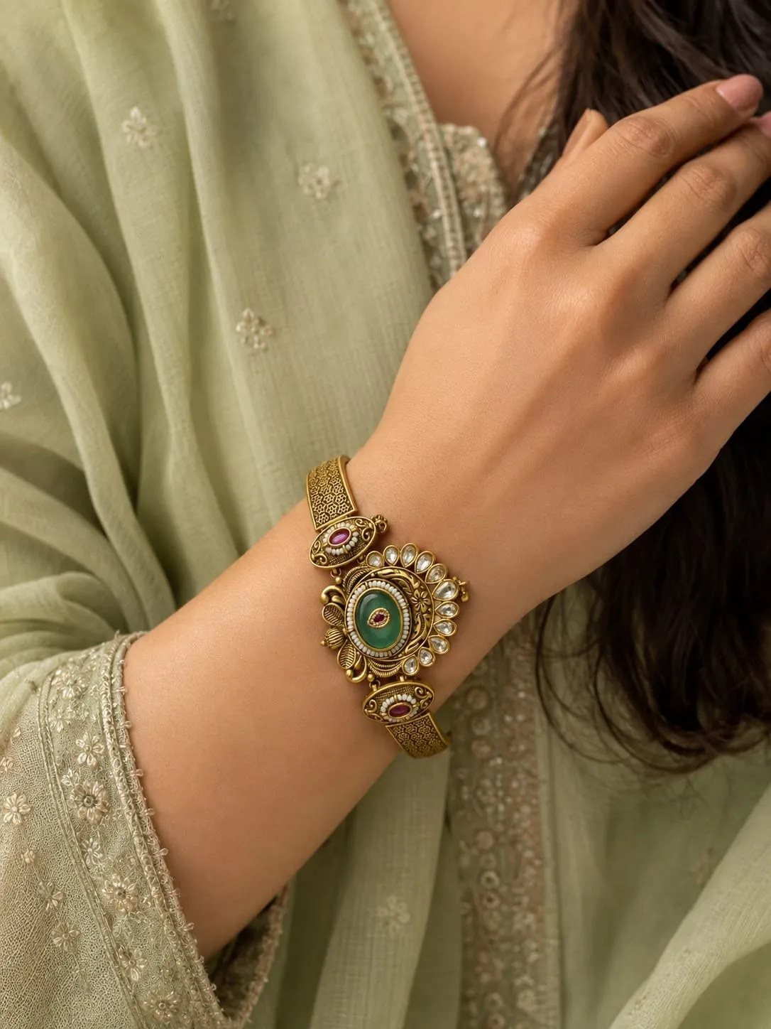 Emerald Royale Heritage Bracelet — Antique gold finish with intricate detailing, Green emerald-inspired centre stone and red synthetic stones and cubic zirconia (CZ) clear stones